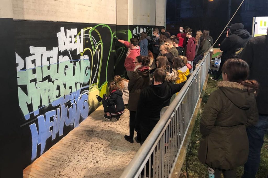 Beim 2. Jugendforum Mutlangen sprühten wir gemeinsam mit den Workshop Teilnehmern das erste Graffiti auf der neue Hall of Fame. Nachdem Micha den Schriftzug auf die Wand skizzierte, malten die ca. 30 jugendlichen das Graffiti Farbe aus.