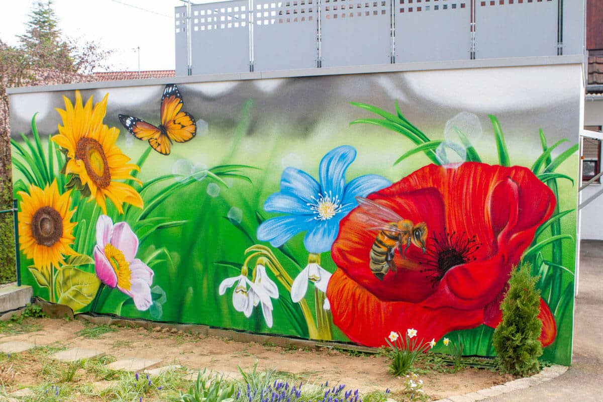 Graffiti Stuttgart wurde für die Gestaltung einer Garagenmauer beauftragt. Passend zum Blumengarten mit dazugehörigem Bienenhotel besprühte Chris die weiße Garagenwand mit einer farbenfrohen Blumenwiese inklusive Biene und Schmetterling.